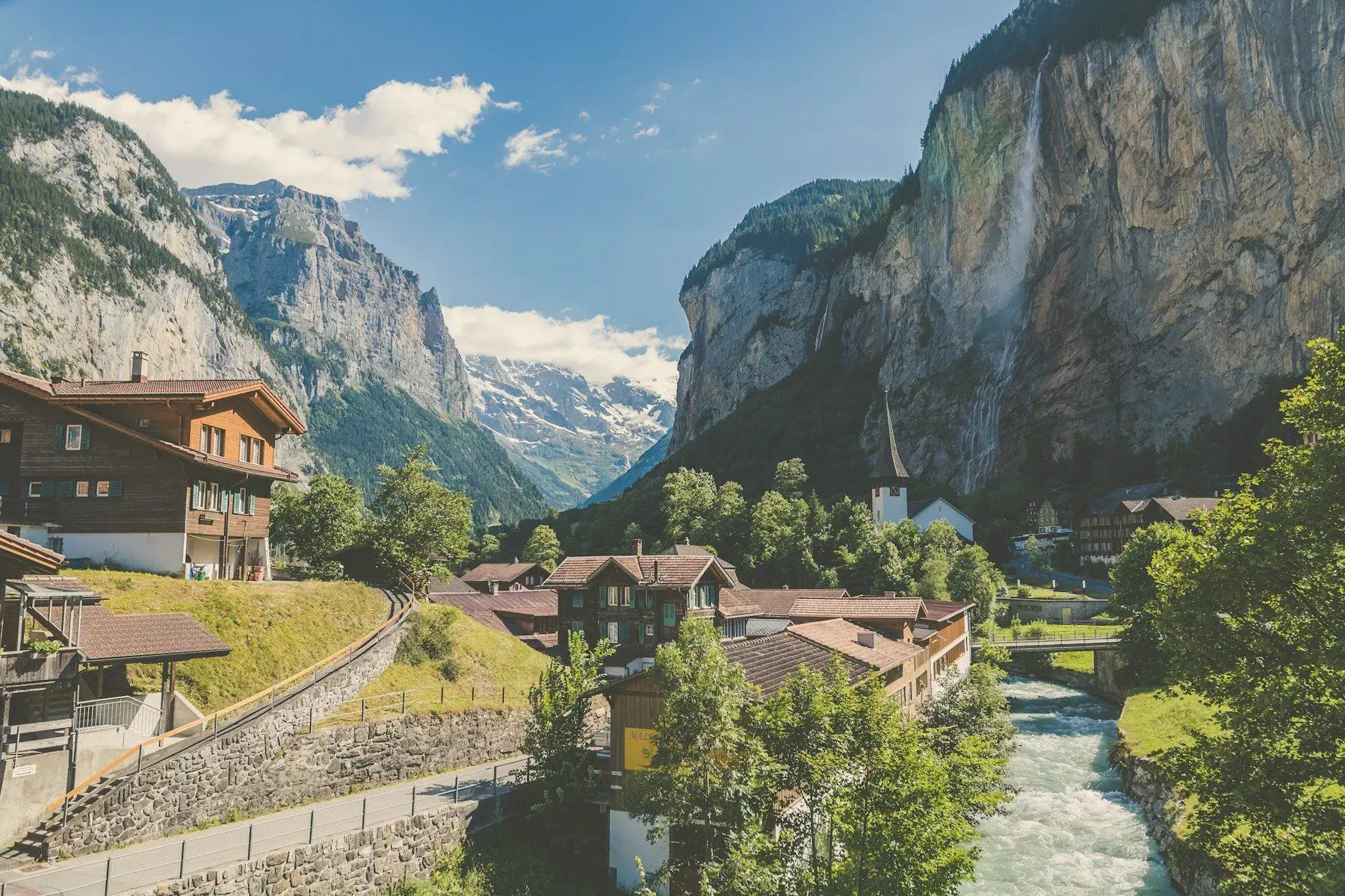A Swiss valley village beneath sheer cliffs and a waterfall