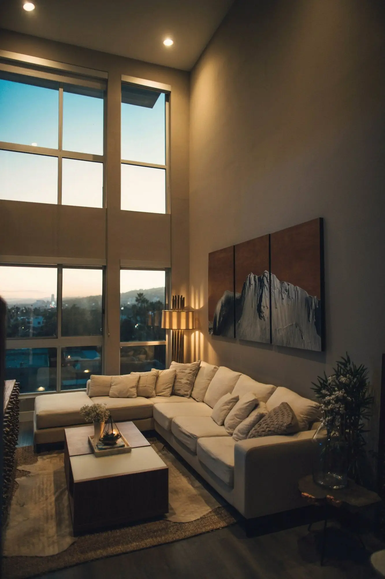 Illustrative image: a double-height suite living room with tall windows