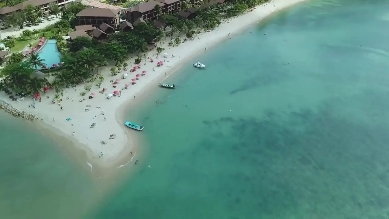 Aerial view of a white-sand spit curling into a turquoise sea